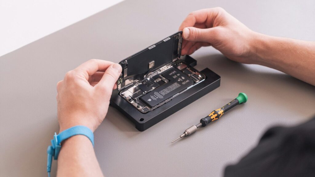 Meistras taiso iPhone ekraną dirbtuvėse